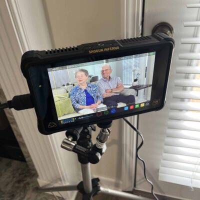 A videographer's viewfinder with a senior couple on the screen