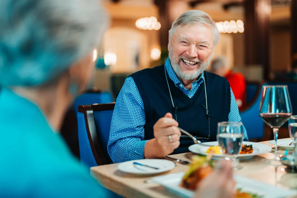 Over the shoulder shot of man smiling and enjoying his meal.