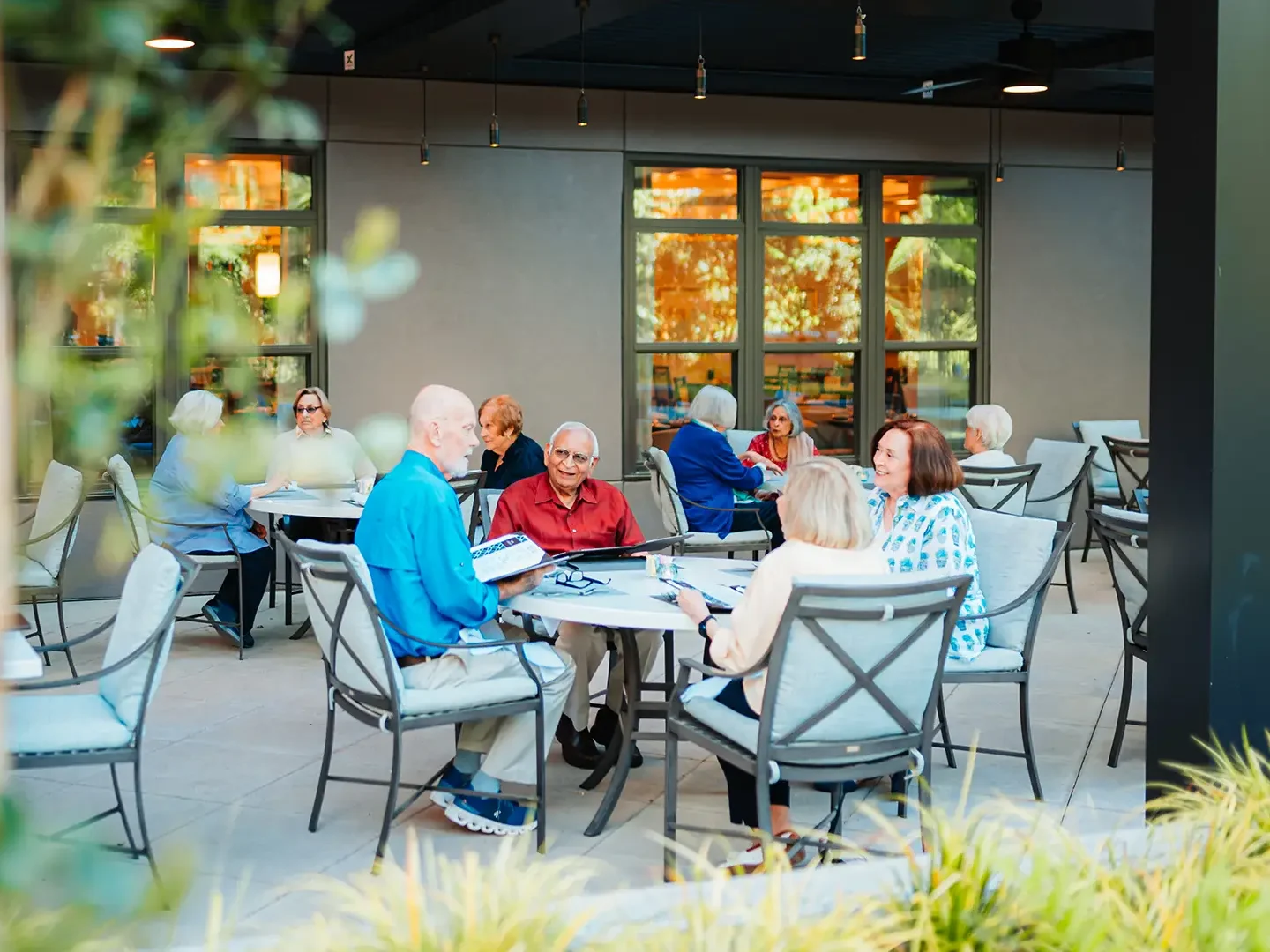 Group of people sitting around an outdoor dining table.