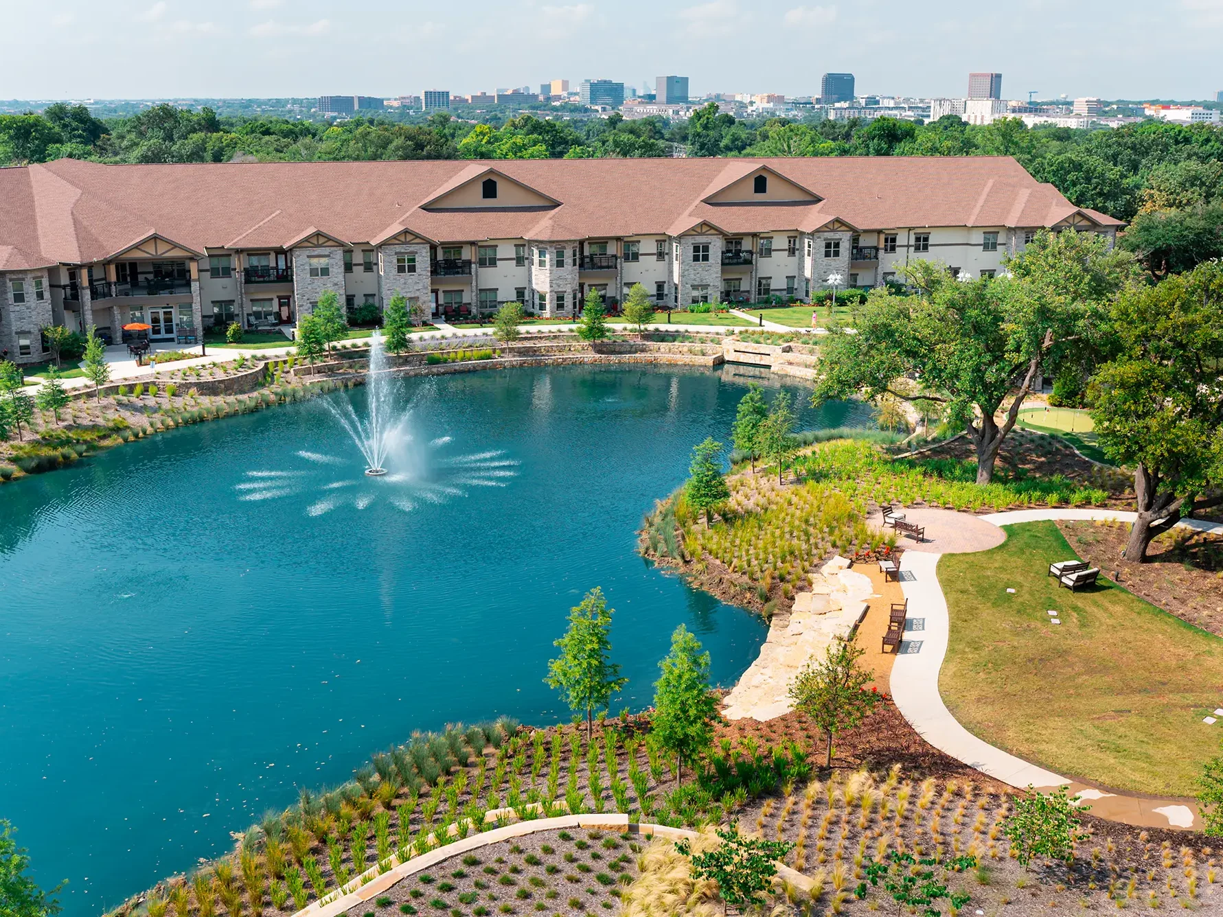 Presbyterian Village North's Campus and fountain with a view of the Dallas skyline.
