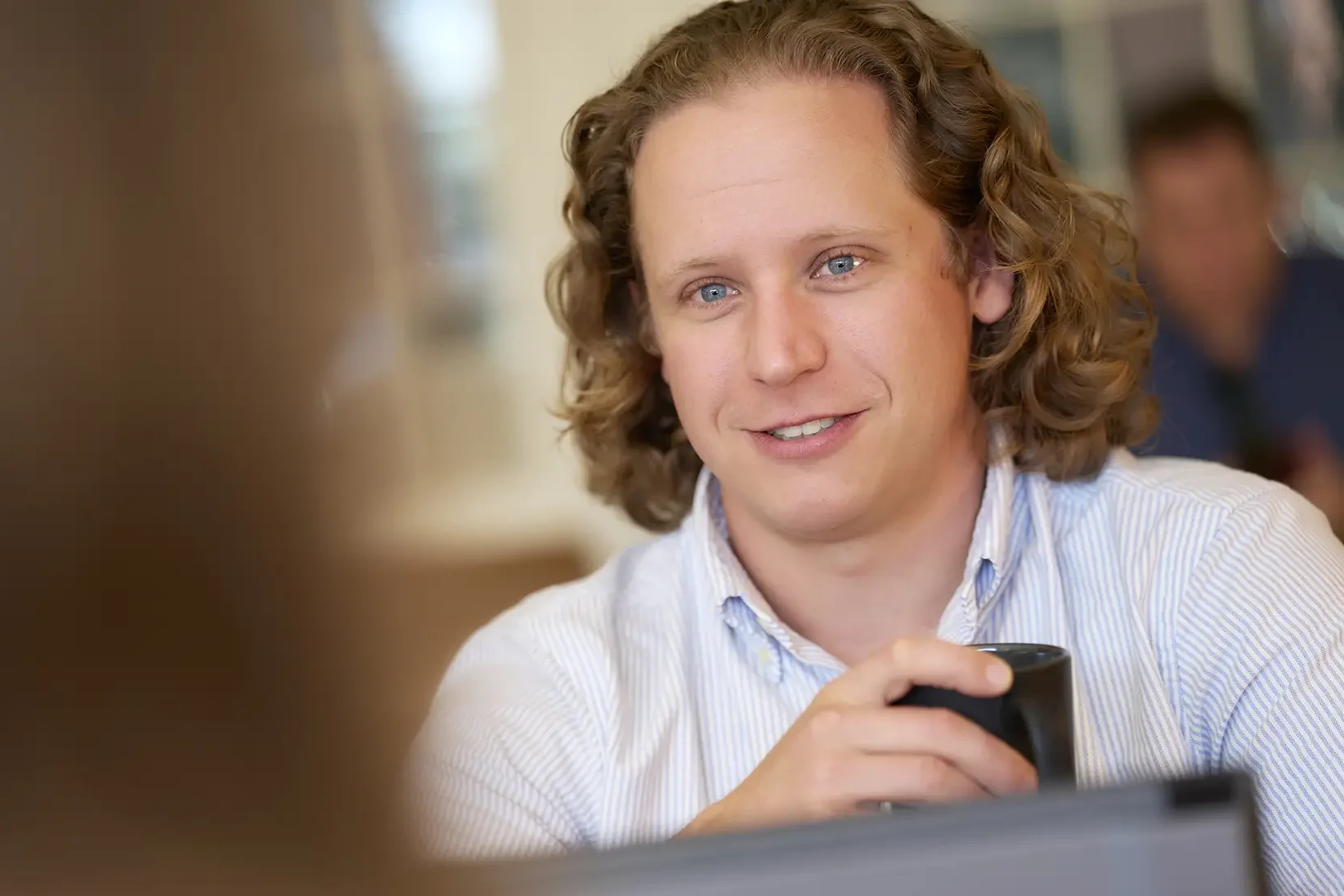 Employee holding a mug.