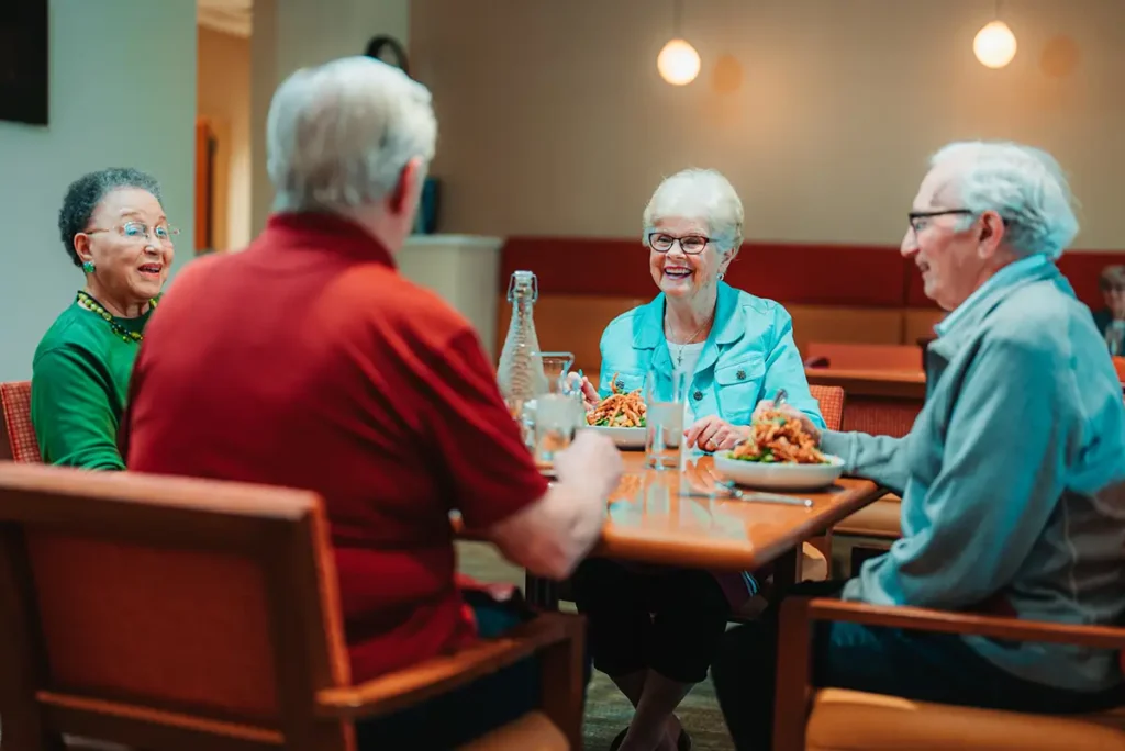A group of senior adults sit at a dining table in a restaurant 